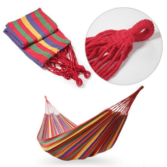 Folded multicolor striped hammock with red braided rope knot detail and fringed ends
