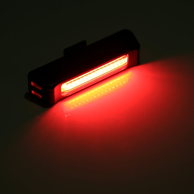 Black head light emitting bright red-tinted beam from front LED strip