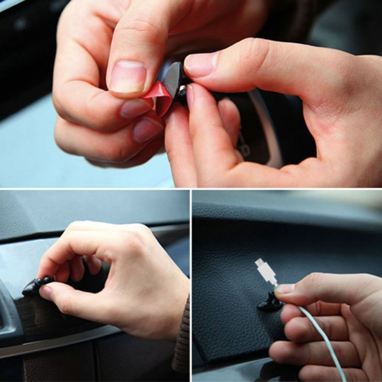 Hands attaching black adhesive cable bundle clips to a car interior surface