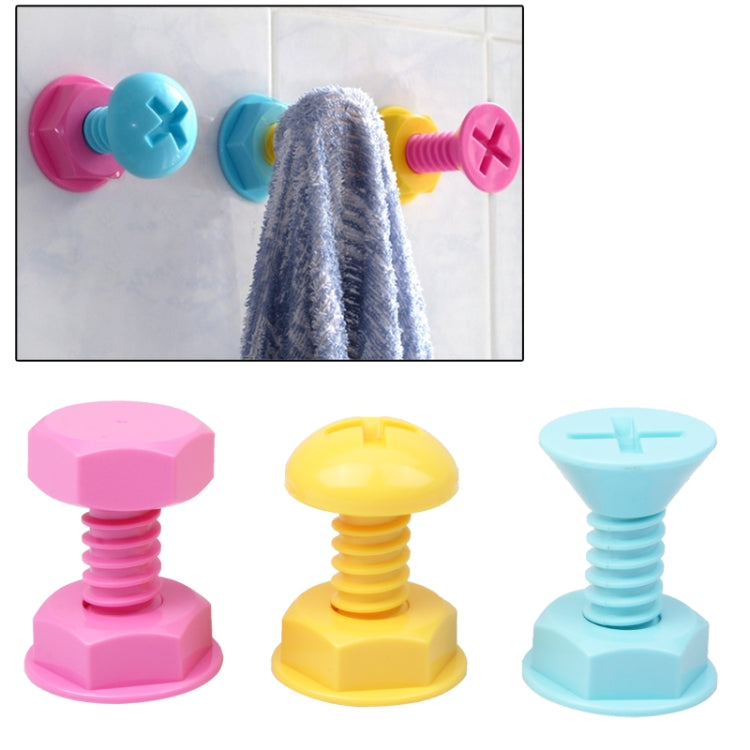 Screw-style wall hooks in pink, blue, and yellow holding a towel