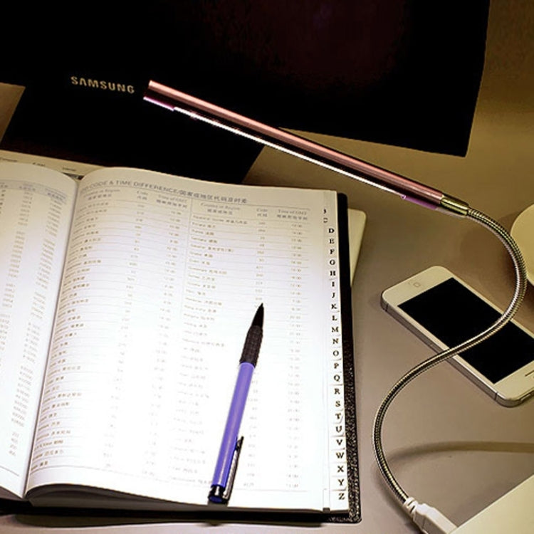 Glowing 10-LED USB LED light bar illuminating a notebook and phone