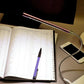 Glowing white LED light bar with USB cable on desk setup
