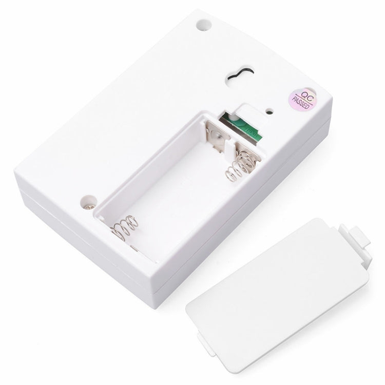 Wireless doorbell remote with open battery compartment showing wiring