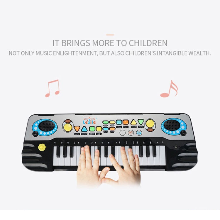 Hands playing a kids electronic keyboard piano with colored control icons and speaker pads