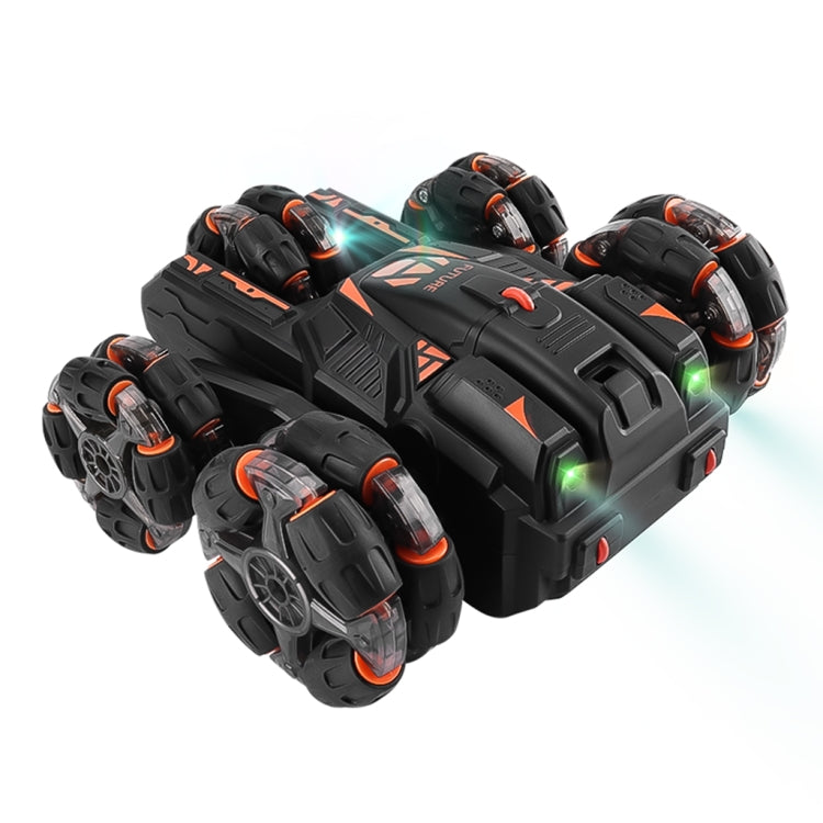 Black RC stunt car with orange trim and five treaded wheels, side view