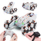 White RC stunt car with orange decals shown with hands using a gamepad remote