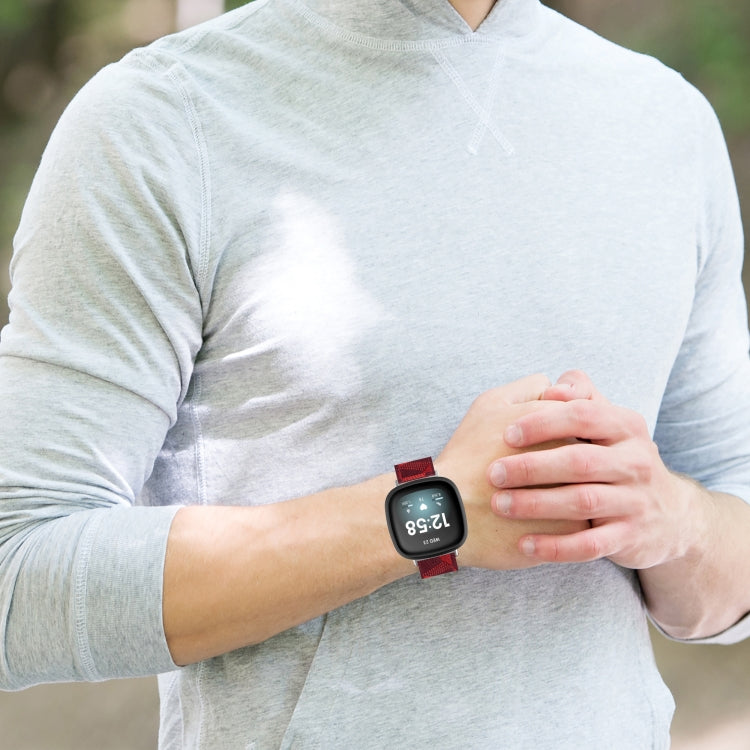 Smartwatch with red nylon weave watch band on a person’s wrist