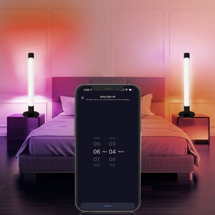 Two color-changing LED light tubes on desktop stands in a bedroom setting