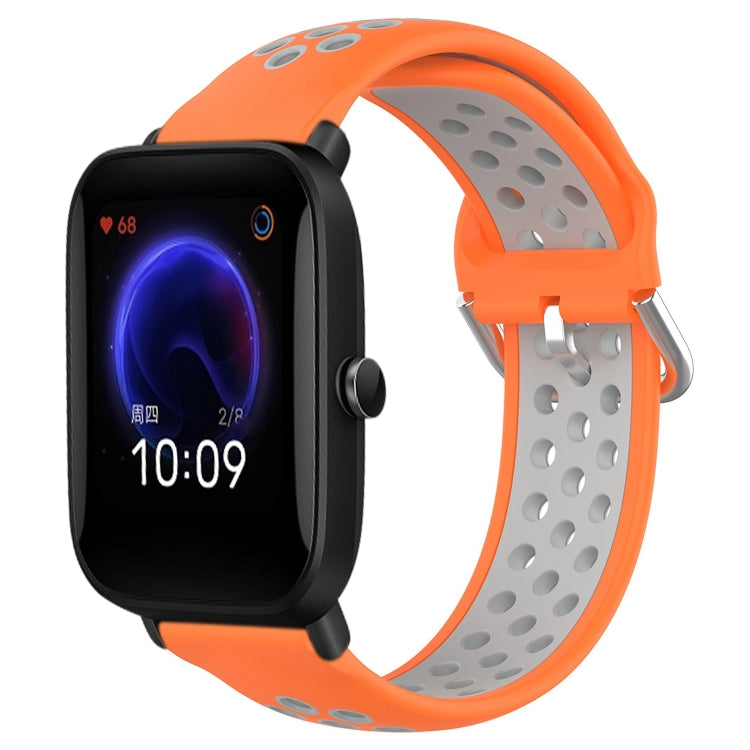 Perforated silicone sports watch band with orange strap and gray perforations, watch shown