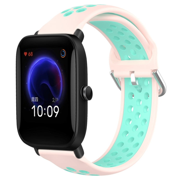 Perforated silicone sports watch band with pink strap and teal perforations, watch shown