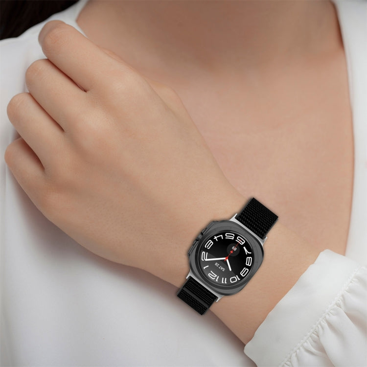 Black nylon hook-and-loop watch band worn on a wrist