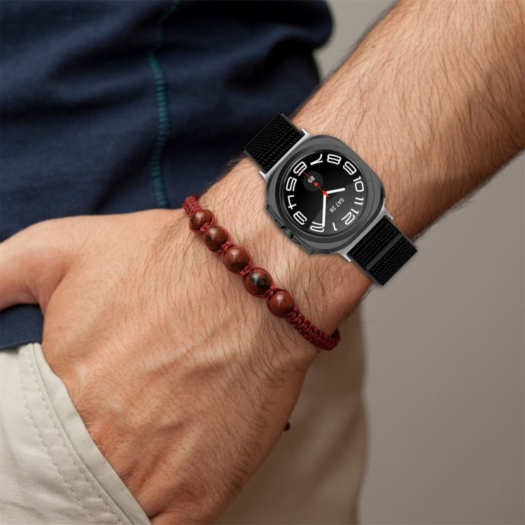 Black nylon hook-and-loop watch band worn beside a beaded bracelet