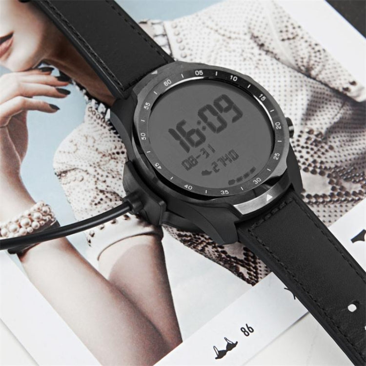 Smartwatch on black strap with magnetic charging cable and puck