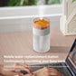 White simulated volcano humidifier on floor, orange-lit dome under clear top
