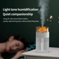 White simulated volcano humidifier with orange glow on bedside table, mist rising