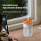 White simulated volcano humidifier with orange-lit dome by window, mist in air