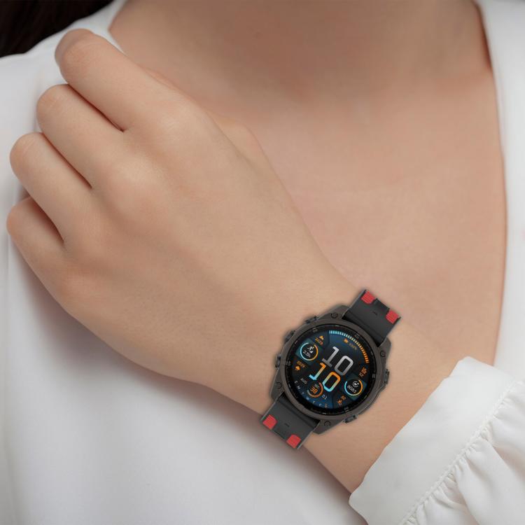 Black silicone watch band with red accents worn on wrist