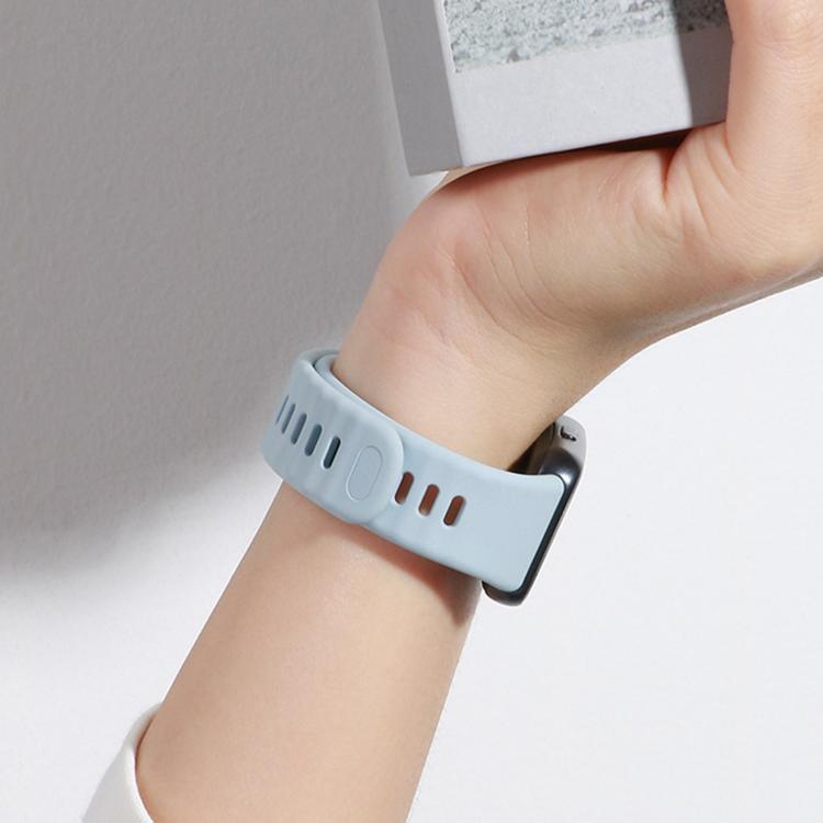 Light blue perforated watch band with a dark buckle, worn on a wrist.