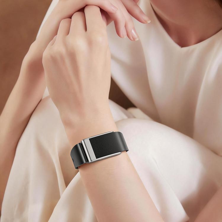 Black vegan leather watch band worn on the wrist, showing its silver-tone buckle