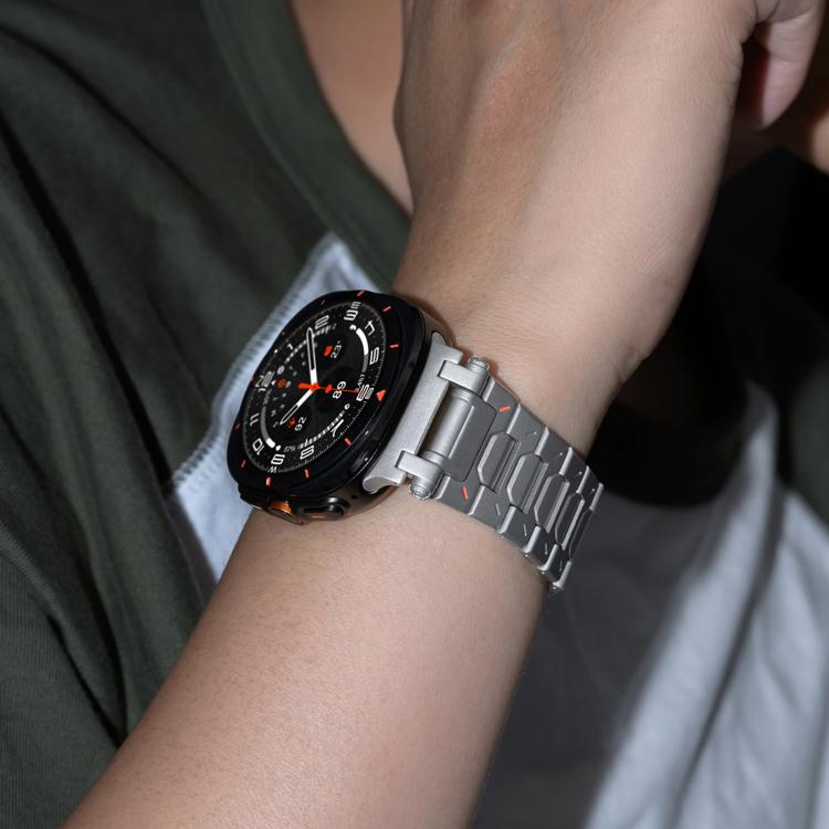 Silver titanium alloy watch band with butterfly clasp worn on a wrist