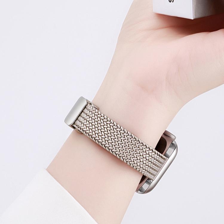 Close-up of a silver stainless steel mesh watch band worn on the wrist