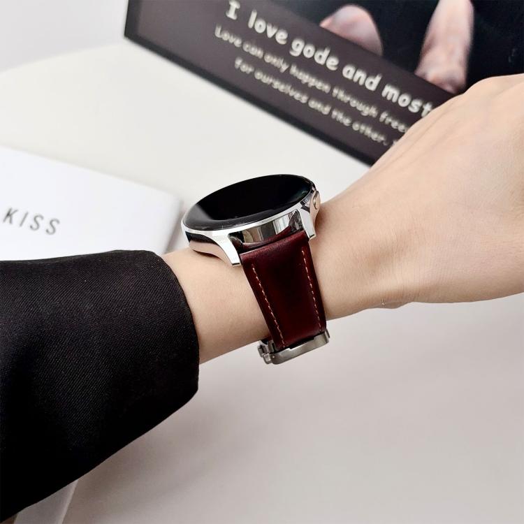 Dark brown leather watch band with light stitching, worn on a wrist