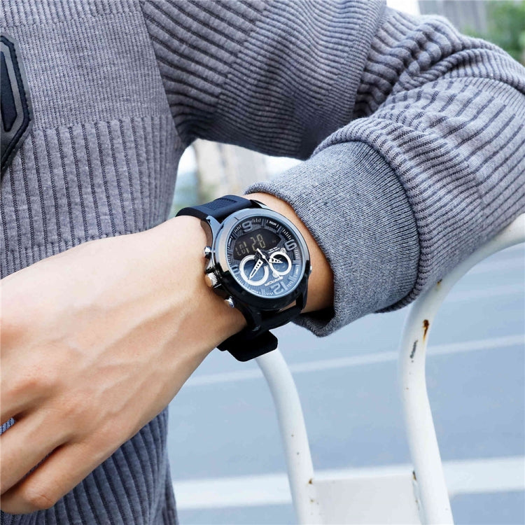 Digital wristwatch on wrist with black case, dark dial, black strap