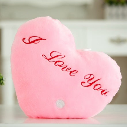 Pink heart-shaped plush glow pillow with red 'I love You' text and small button