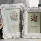 Pair of white carved floral picture frames with rose bouquet and easel bases