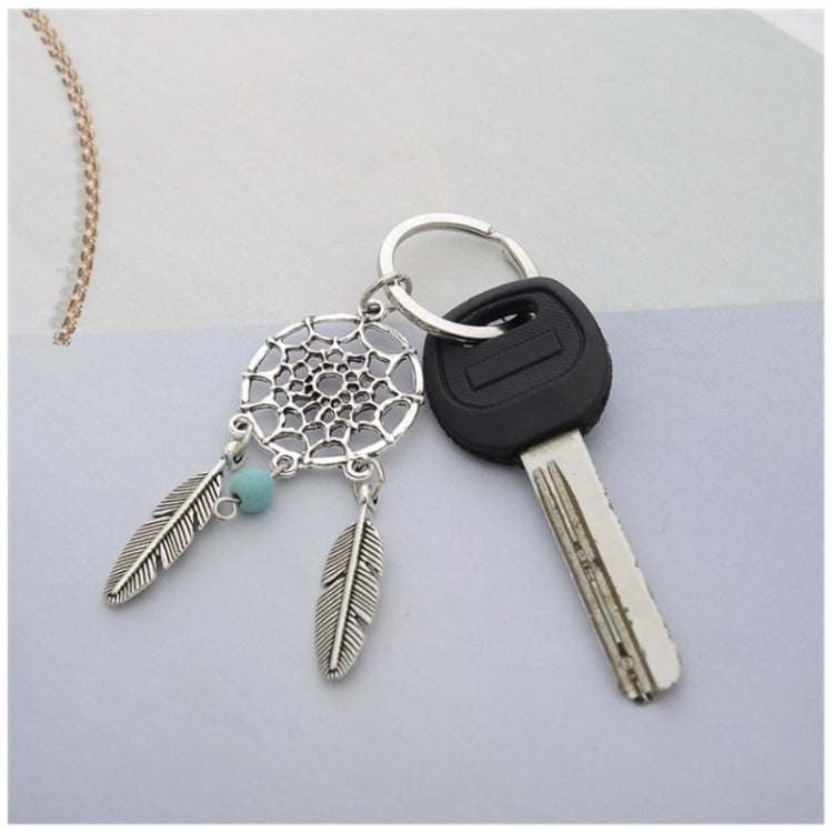 Silver dreamcatcher keychain with teal bead, three feathers, and black key fob