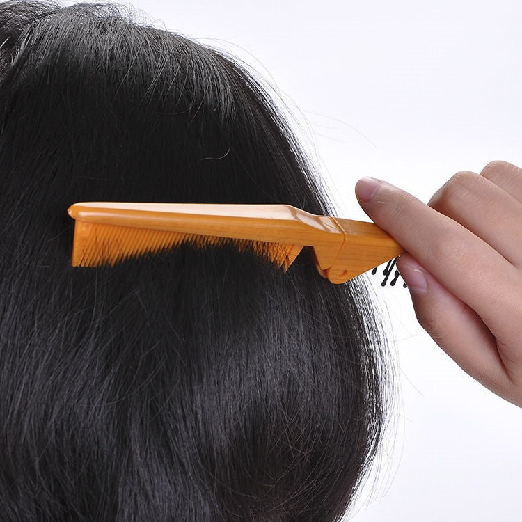 Orange comb attachment with fine teeth used on the top of hair