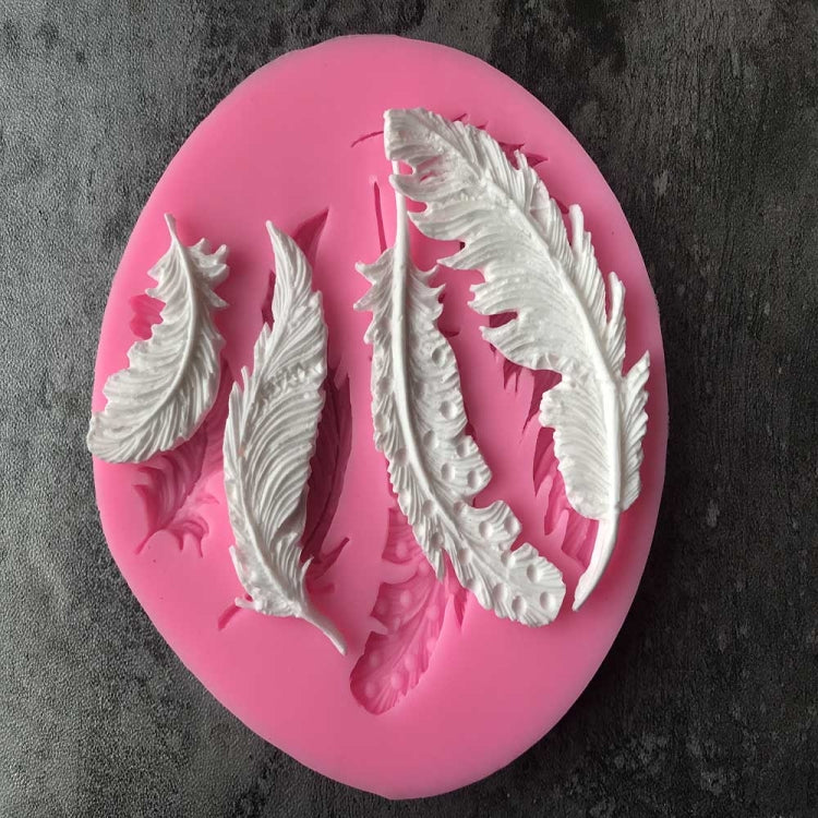 Pink silicone mold showing five raised feather designs, seen from above