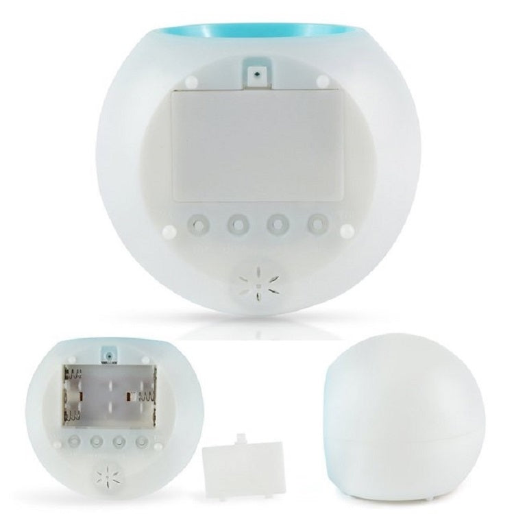 Round alarm clock with open battery compartment and display module, shown from the back