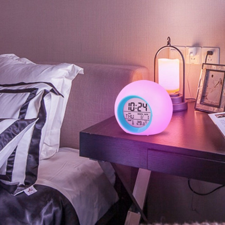 Round LED alarm clock with pink glow display showing time and temperature at night