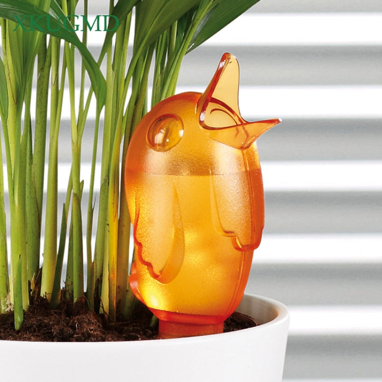 Orange bird-shaped garden sprinkler in a planter pot