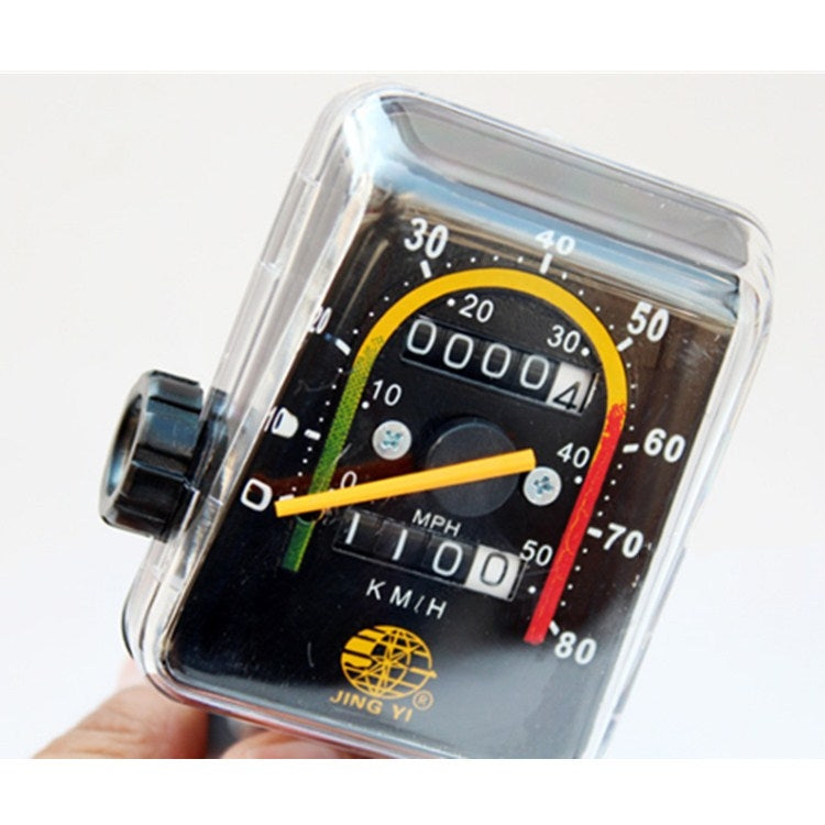 Close-up mechanical odometer display with reading and MPH/KMH scale under clear cover