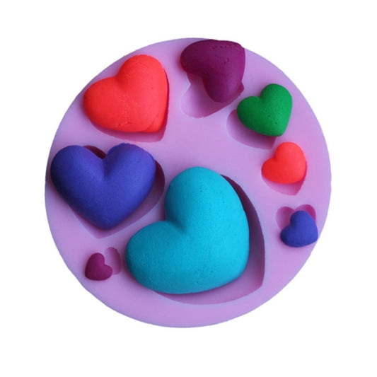 Heart-shaped silicone baking mold with colorful fondant hearts in heart cavities
