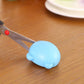 Blue handheld knife sharpener resting on wood with sharpening slot