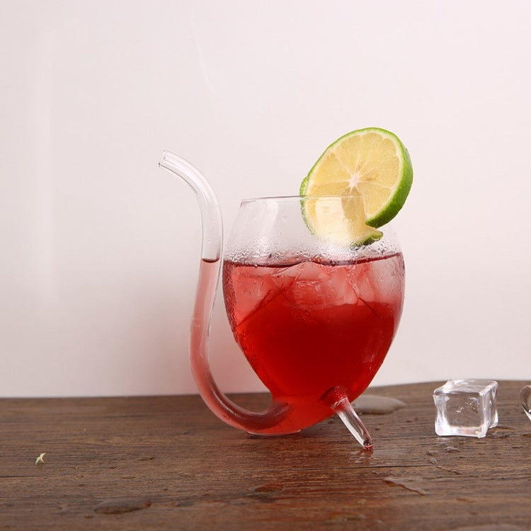 Clear glass juice mug with straw, filled with red drink and lime wedge