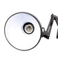 Close-up of round light head on black swing arm desk lamp