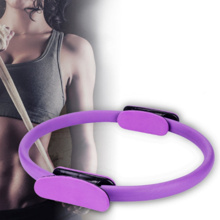 Purple Pilates ring with foam pads, shown near torso during exercise
