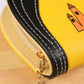 Yellow puppy zipper wallet clutch close-up of black stitched trim and metal zipper pull