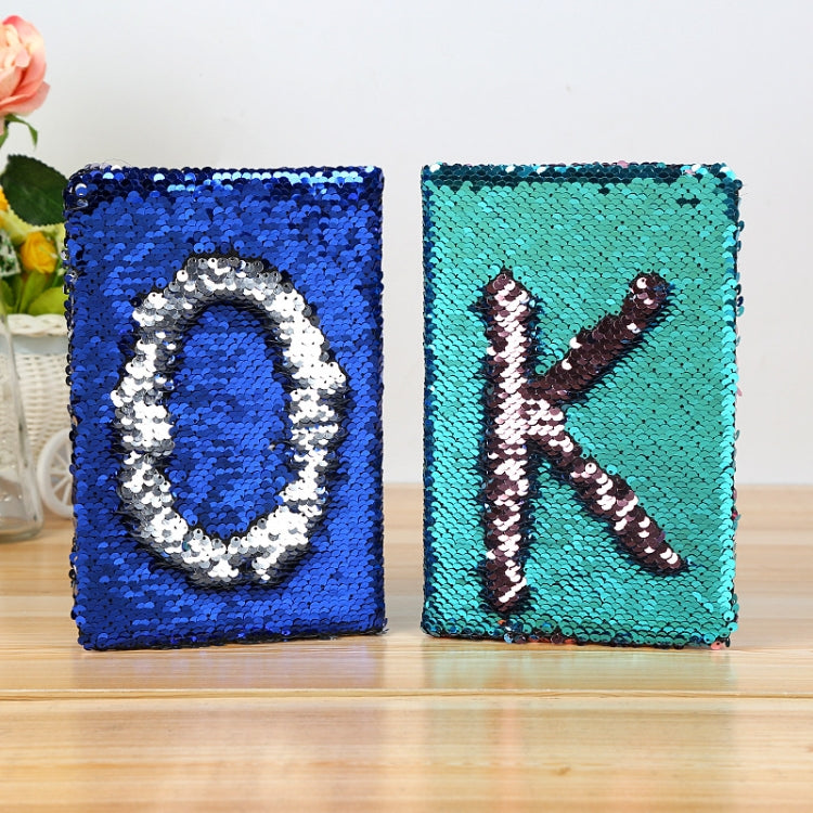 Lake blue sequin flip notebook with dark K letter, shown beside another sequin notebook