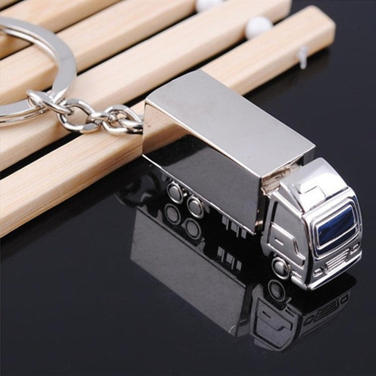 Metal van-shaped keychain pendant with chain and split ring, angled view