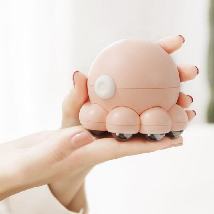 Pink octopus shoulder massager held in hands, round control pad on top