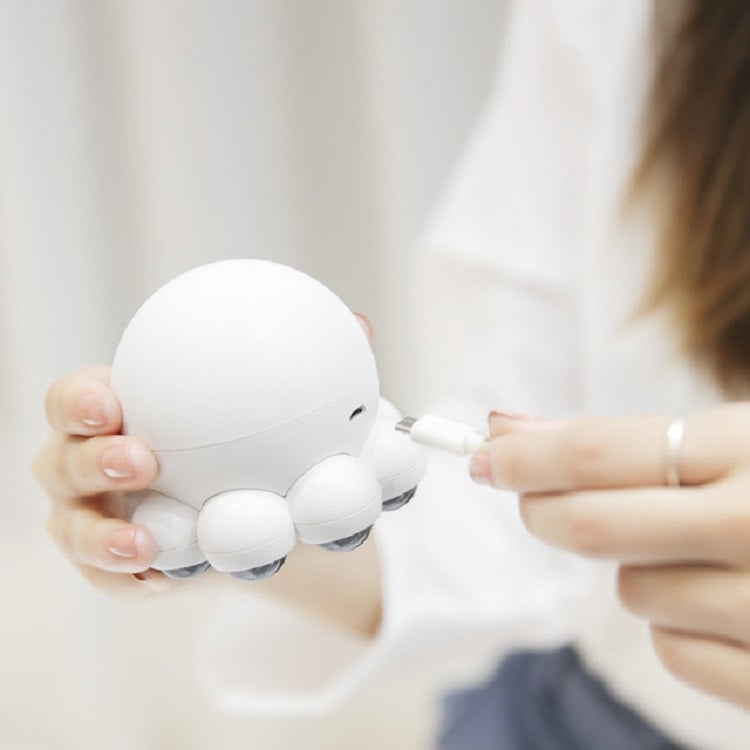 Cream octopus massager held to the shoulder with round control pad