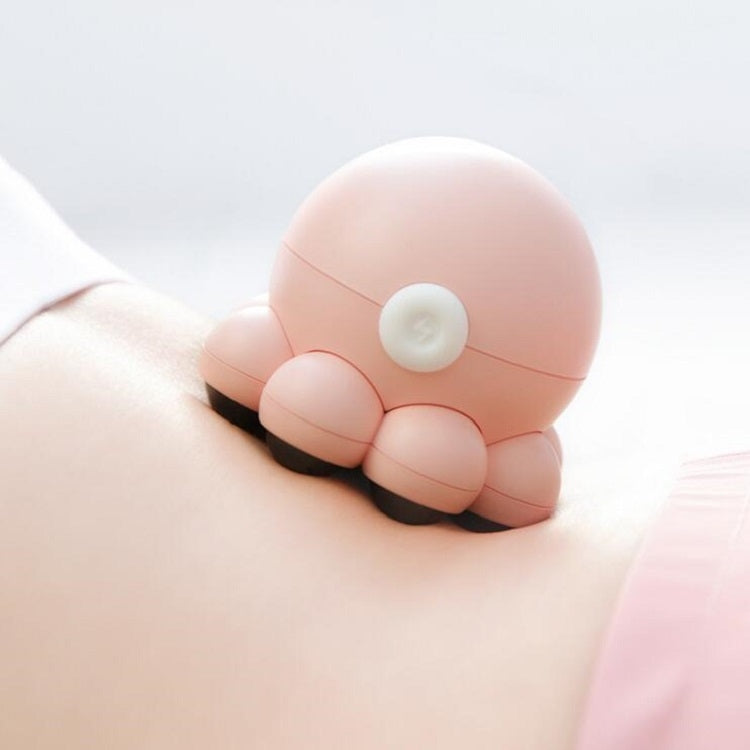 Pink octopus shoulder massager placed on upper arm, black feet and top control pad