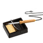 Black square soldering iron stand holding a soldering iron with sponge pad inside