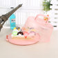 Pink round-handle plastic cake storage box with domed lid, containing assorted pastries.