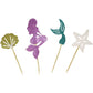 Mermaid cupcake toppers close-up: purple figure, gold fan, teal tail, white star on sticks